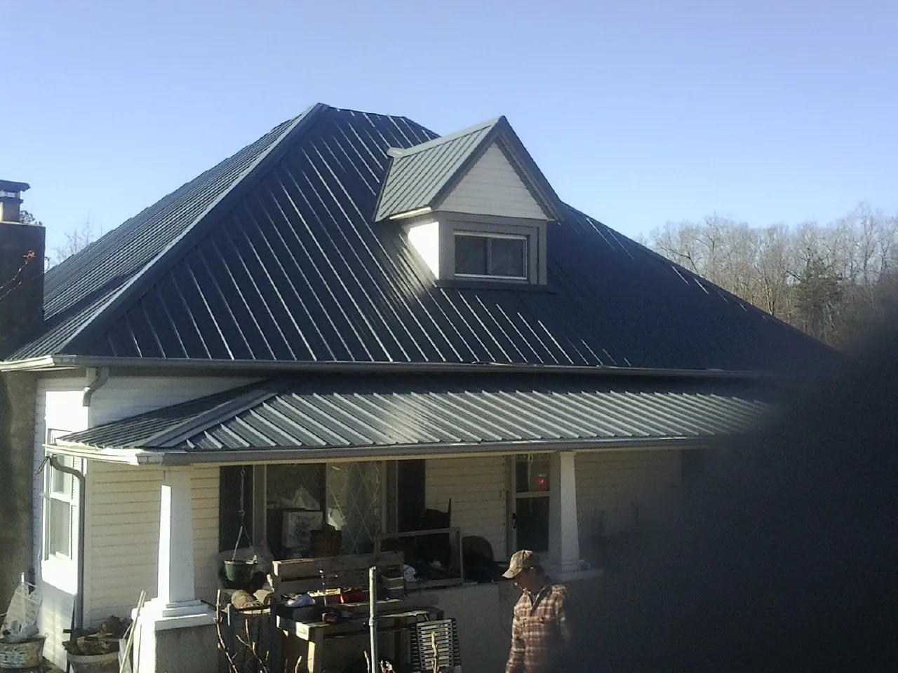 Dark blue standing seam metal roof with a dormer above a front porch in Suitland