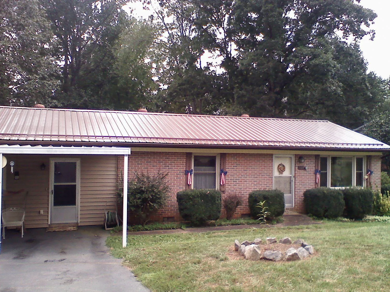 Bronze metal roof and carport on a brick ranch home — Roof Repair work by our crew in Suitland